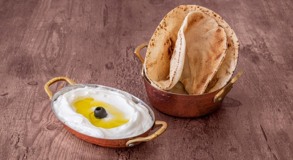Labné libanais maison servi avec huile d'olive et pain pita frais au restaurant King Libanais Maison des Galettes à Paris 10